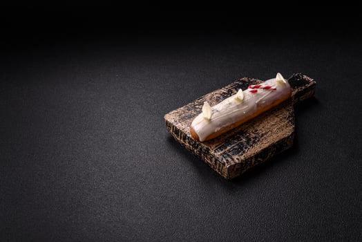 Sweet eclair with chocolate filling covered with white glaze photo