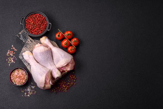 Raw chicken or turkey legs with salt, spices and herbs photo