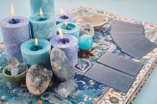 Mystical Card Reading Setup. Blue candles, crystals, and tarot cards on a patterned cloth. photo