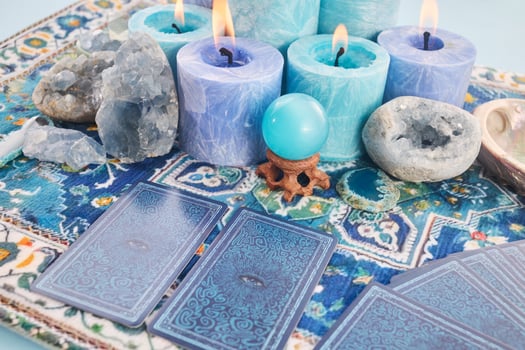 Mystical Card Reading Setup. Blue candles, crystals, and tarot cards on a patterned cloth. photo