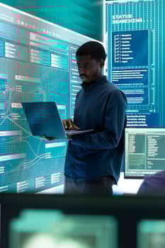 Governmental hacking specialist targeting sensitive information through high tech cyber attacks, digital espionage with a laptop and big screen. Hacker working on national security and data privacy. photo