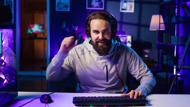 Gamer in neon lit home feeling upset after losing against opponent in online esports competition. Player punching desk in frustration after being defeated by enemy in videogame internet tournament photo