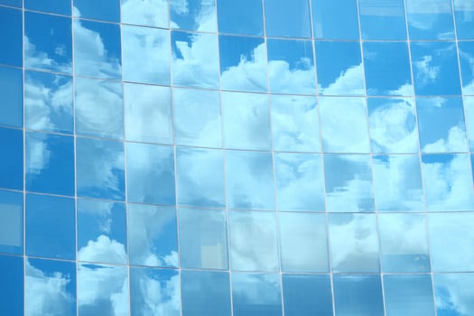 A modern office building facade with large glass windows that reflect its surroundings photo