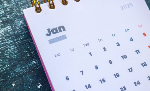Close up of January 2025 in the pink 2025 calendar on the table. Calendar and Note Pad Happy New Year 2025. Zoomed in first of January 2025 in the calendar photo