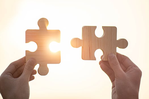 Two hands connect couple puzzle piece with sunset background. photo
