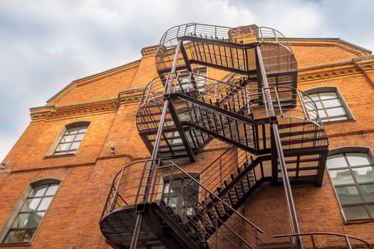 Red brick business building back with rough metal stairs. photo
