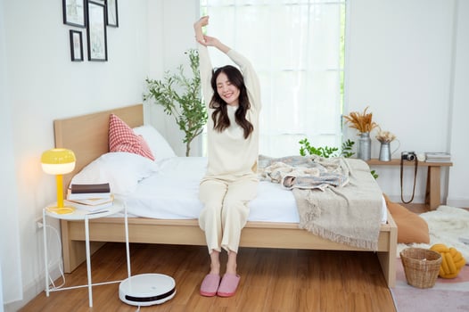 Young asian woman stretching in bed after Waking up in the Morning photo