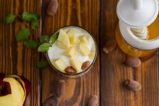 Healthy dessert. sweet homemade yogurt in a glass with apples, nuts and honey photo