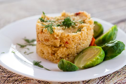Ideal breakfast. homemade cooked bulgur with Brussel sprouts in a plate, on a wooden table photo