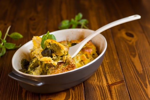 Vegetarian food. cauliflower and brussels sprouts casserole with cheese, in a ceramic dish on a wooden table photo