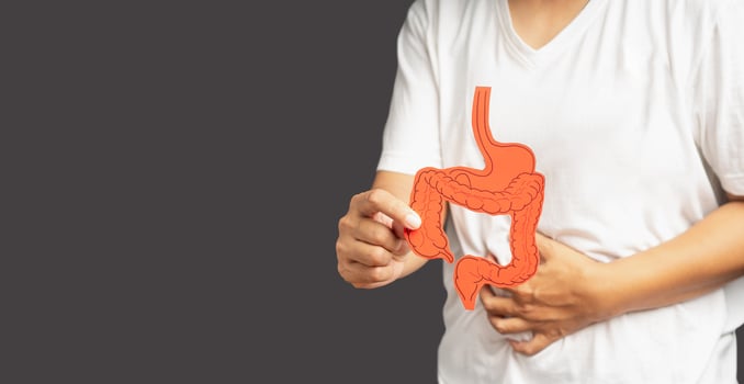 Hand holding a colon symbol and touching stomach painful suffering from gastrointestinal system disease photo