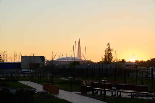 A breathtaking view of a sunset over an urban park surrounded by elegant modern architecture photo