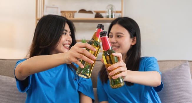 A lesbian couple cheers football and celebrate together for their favorite Euro football team. A young female couple cheers football on TV together in the living room on match day. photo