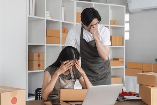 Stressed Couple Analyzing Stock Market Data Online at Home Office with Laptop and Boxes photo