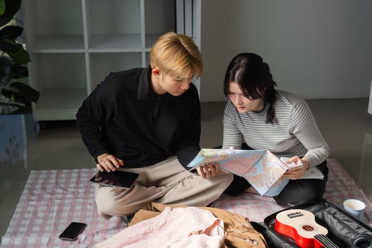 Young Couple Enthusiastically Planning and Packing for Their Upcoming Vacation Adventure at Home photo