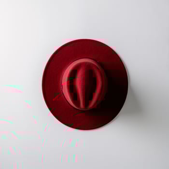 A stylish red felt hat placed elegantly on a white background. photo