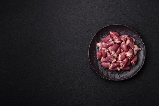 Raw chicken hearts with salt, spices and herbs photo