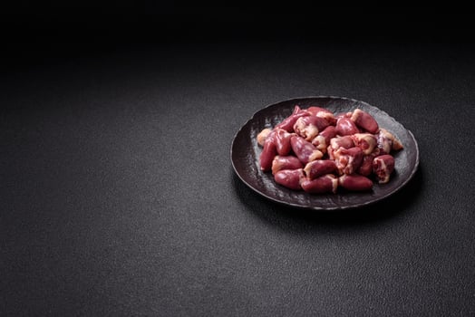 Raw chicken hearts with salt, spices and herbs photo