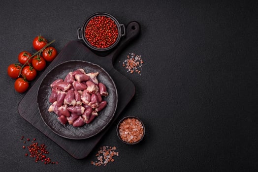 Raw chicken hearts with salt, spices and herbs photo