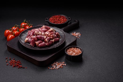Raw chicken hearts with salt, spices and herbs photo