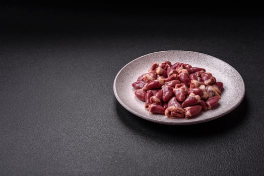 Raw chicken hearts with salt, spices and herbs photo