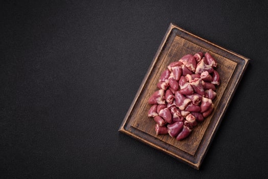 Raw chicken hearts with salt, spices and herbs photo