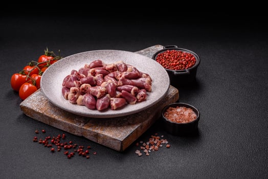 Raw chicken hearts with salt, spices and herbs photo