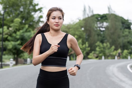 Woman Jogging in the Park on a Sunny Day, Embracing Fitness and Nature, Wearing Black Sportswear and Smartwatch photo