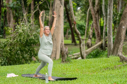 Healthy Elderly Woman Stretching and Exercising in a Lush Green Garden for Wellness and Fitness photo
