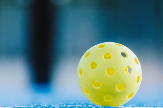lone pickleball ball in a pickleball court, racket sports background photo