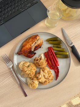 Delicious meal featuring roasted chicken and vegetables on a wooden table photo