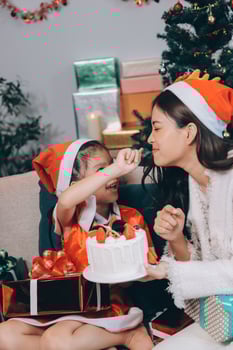 Merry Christmas and Happy Holidays. Cheerful mom and her cute daughter girl exchanging gifts. Parent and little child having fun near tree indoors. photo