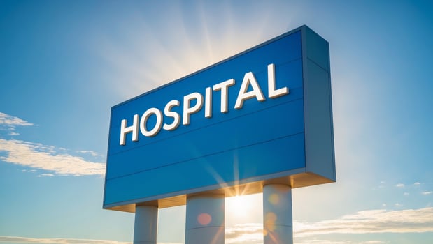 Bright hospital sign under the sun with a clear blue sky for medical facility identification photo