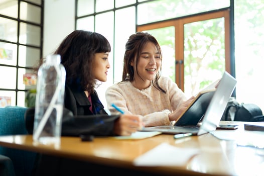 Friends Studying Together at a Cafe Working on Academic Projects photo