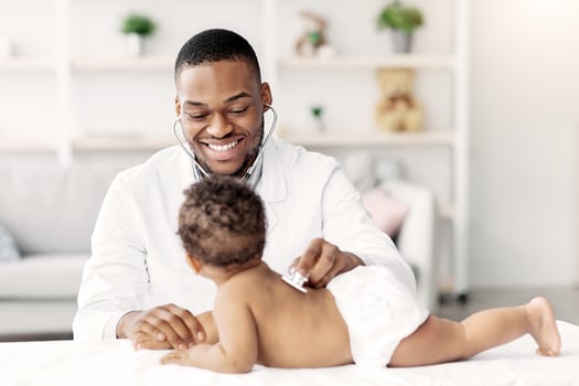 Medical Checkup. Smiling Black Pediatrician Doctor Examining Little Baby With Stethoscope During Appointment In Modern Clinic, Professional Therapist Checking Health Of Infant Child, Free Space photo