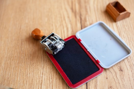 Traditional Handheld Office Date Stamp and Ink Pad on Desk. photo