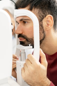 Patient undergoing eye examination with modern equipment in ophthalmology clinic photo