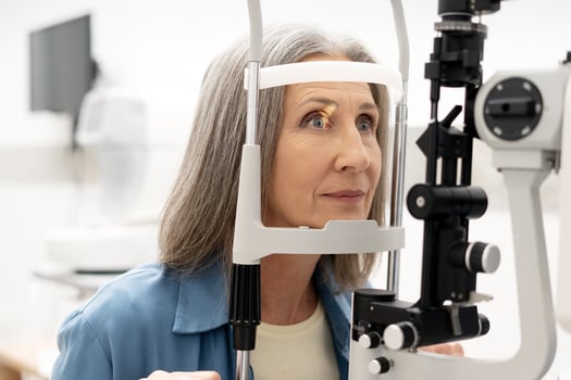 Senior woman undergoing eye examination with slit lamp biomicroscope photo