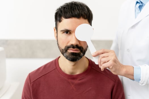 Doctor examining patient's vision with occluder in medical clinic photo