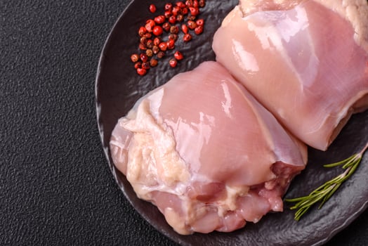 Fresh raw chicken thigh fillets with salt, spices and herbs photo