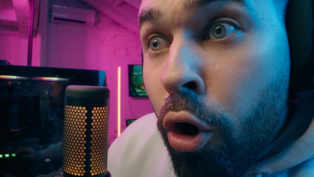 Astonished shocked Caucasian vlogger guy male laugh blogger influencer close up surprised man gaming addicted male streamer play cyber sport online game pc computer neon amazement wow emotion at home photo