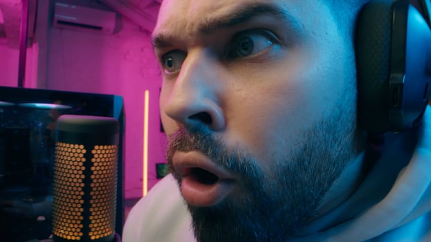 Astonished shocked Caucasian vlogger guy male laugh blogger influencer close up surprised man gaming addicted male streamer play cyber sport online game pc computer neon amazement wow emotion at home photo