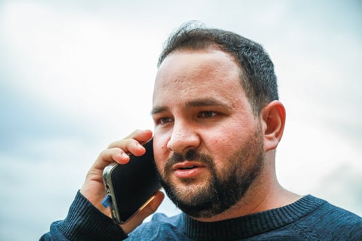 Man Clutches Phone While Hearing Tragic News photo