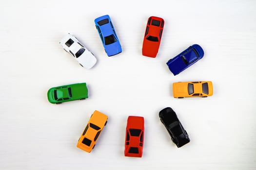 Colorful toy cars arranged in a circle on a white background, photo