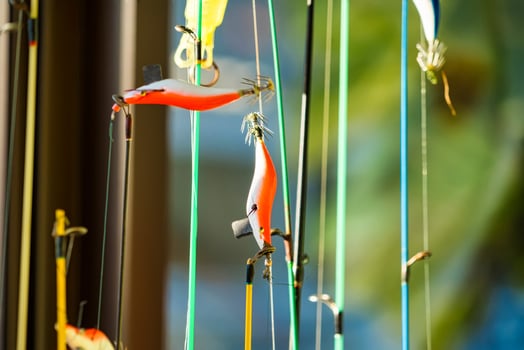Brightly Colored Fishing Lure Hanging from a Line, Ready for Use in Outdoor Angling Adventures. photo