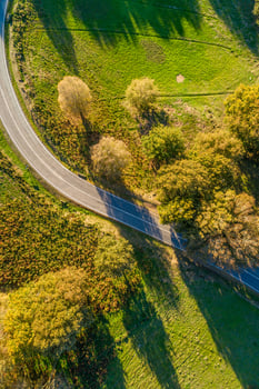 directly above aerial drone view of a mountain road curve in spring photo