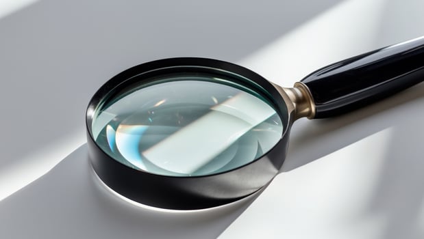 A magnifying glass is shown on a white surface photo