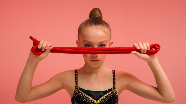 Little girl sportswoman female gymnast acrobat ballerina dancer with skipping rope in pink studio sport class education strong serious child looking camera kid daughter schoolgirl teen workout ballet photo