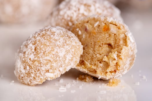 Beautiful sweets with coconut on a white plate on a black background photo