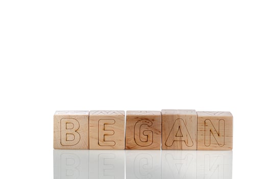 Wooden cubes with letters began on a white background photo